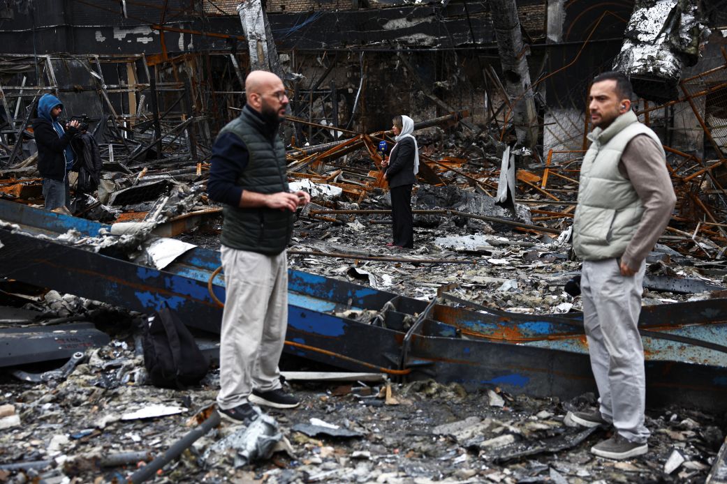 Journalists work at the site of a car repair shop and dealership damaged by a strike amid the US-Israeli conflict with Iran, in Tehran, Iran, on March 28.